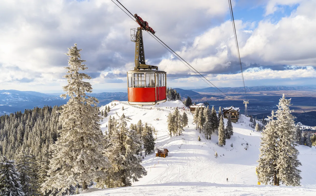 Landscape from top of Postavaru mountain with ski slopes and cable car transporting in Poiana Brasov, Romania