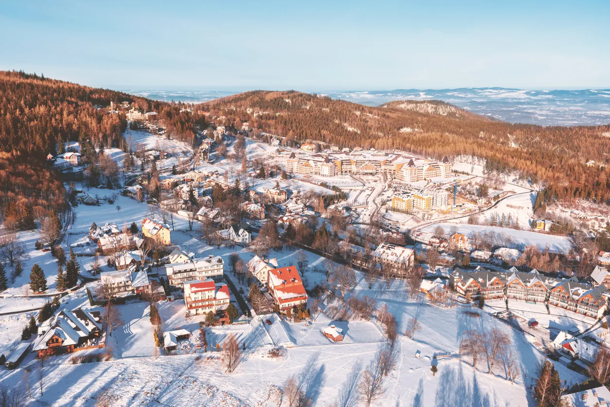 Winter city among the forest in the mountains. View of the winter landscape from a drone. Karpacz. Poland
