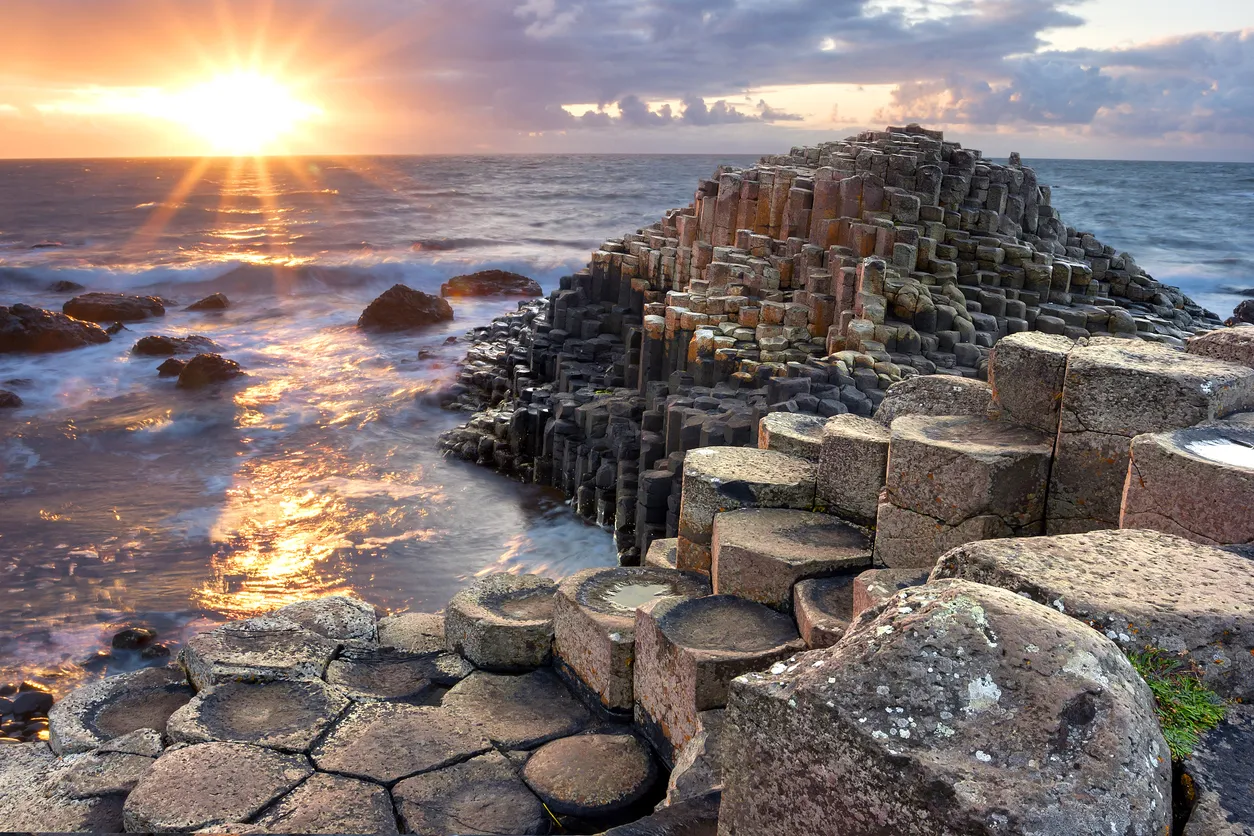 People visiting Giant s Causeway at the sunset in North Antrim, Northern Ireland