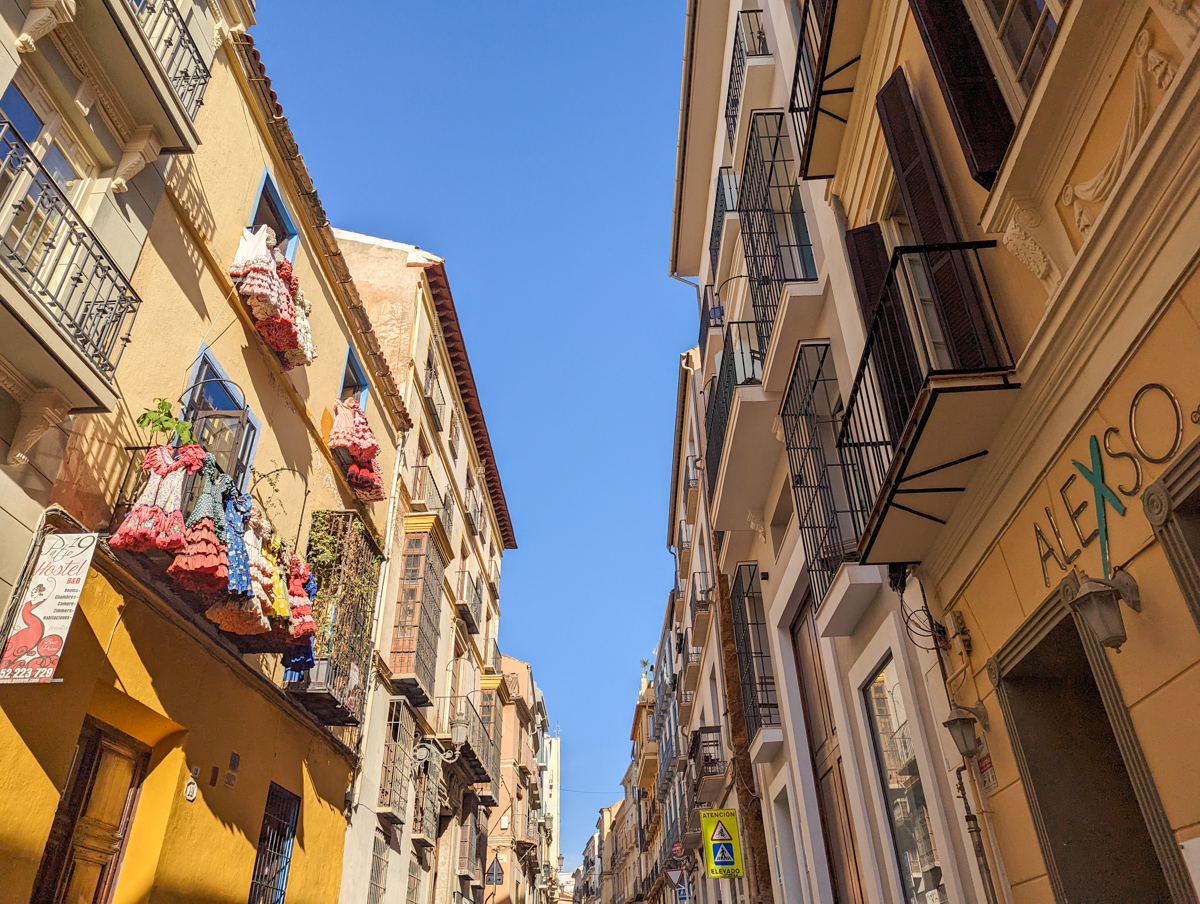 The narrow streets in Malaga old town with historic buildings on either side. 